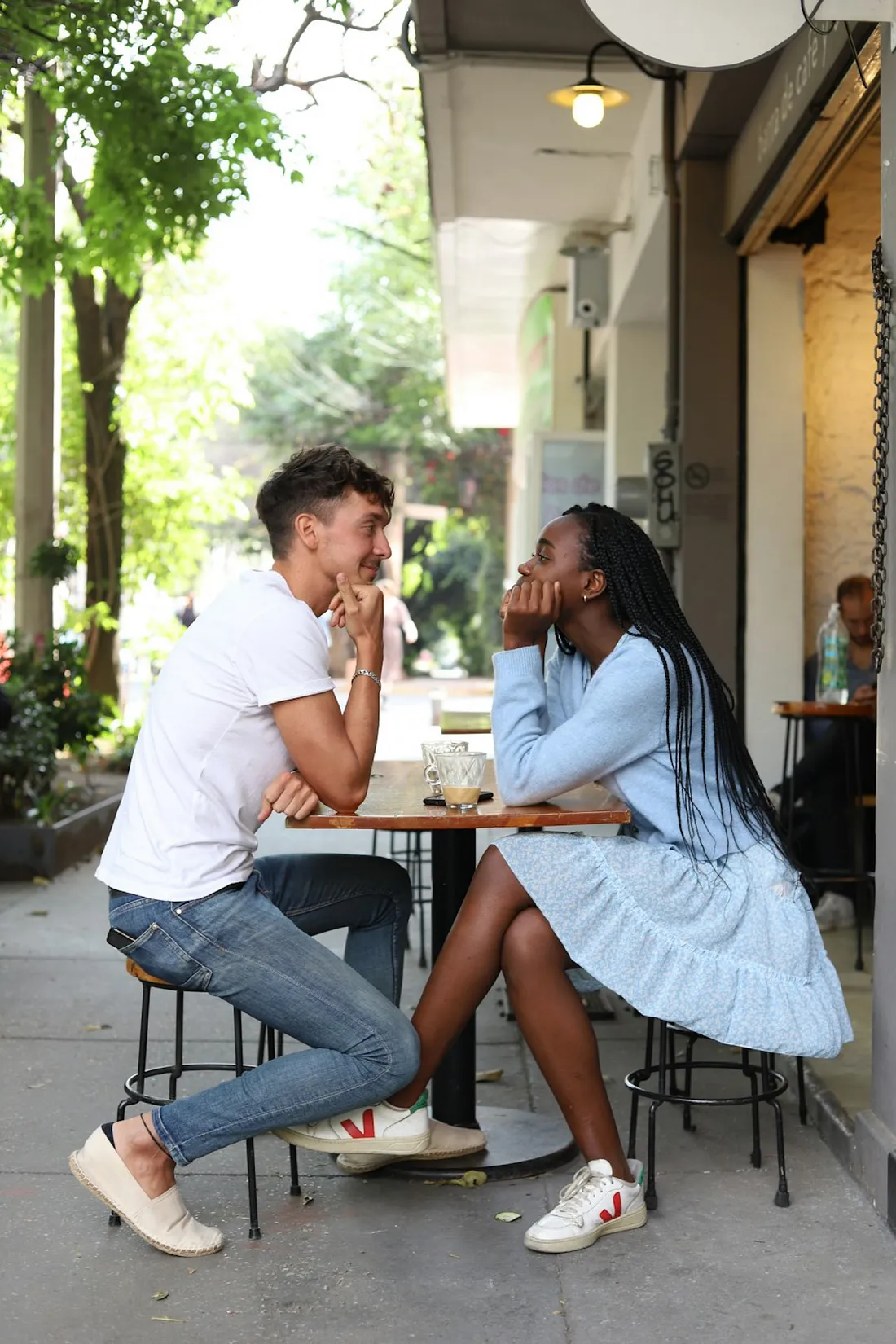 Two people sharing a heartfelt moment at a cozy outdoor café, symbolizing the warmth and connection of an unexpected friendship.